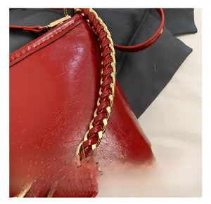 Close-up of gold chain strap and red textured leather on the stylish shoulder bag