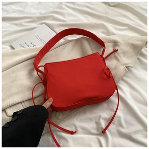 Vue détaillée d'un sac à bandoulière rouge avec cordons de serrage décoratifs