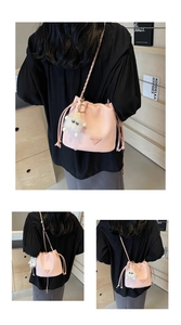 Detailed view of pink drawstring bucket bag with lychee texture and plush charm