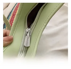 Macro shot of silver metal zipper detail on a colorful woven tote with light green trim