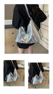 Silver metallic hobo bag with zip details shown on model in a minimalist setting