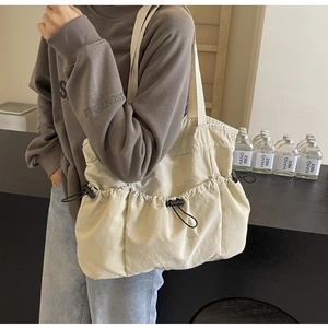 Detailansicht einer beigen Nylon-Einkaufstasche mit Kordelzugtaschen und Webgriffen