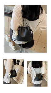 Detail of black bucket bag with chain strap and cute white lamb plush pendant charm