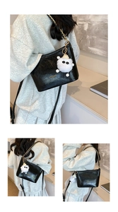 Detail of black glossy PU leather bag with gold chain and plush cat charm