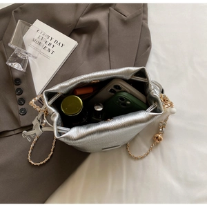 Silver bucket bag interior showing capacity for smartphone and cosmetic essentials