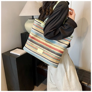 Detail of colorful woven tote bag featuring vibrant stripes and durable top handles