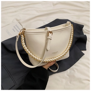 Close-up of the beige chain bag showing the metallic accents and adjustable strap
