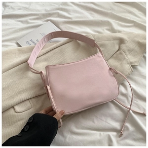 Détail du sac à bandoulière rose avec large sangle et cordon de serrage sur tissu doux