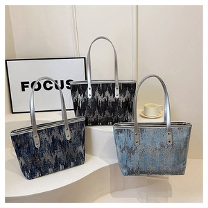 Detailed view of large tote bags in navy, black, and blue with woven geometric textures