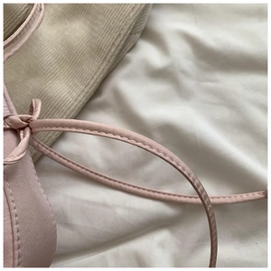 Détail du tissu satiné rose avec double couture fine et design élégant de ruban noué