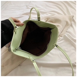 Inside view of green tote bag showing dark brown lining and interior zipper pocket
