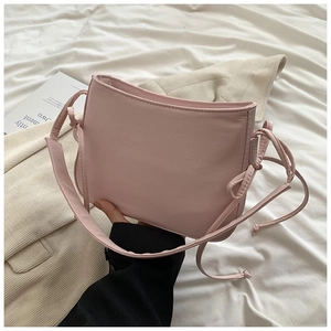 Détail du sac à bandoulière en cuir PU rose pâle avec ruban latéral décoratif