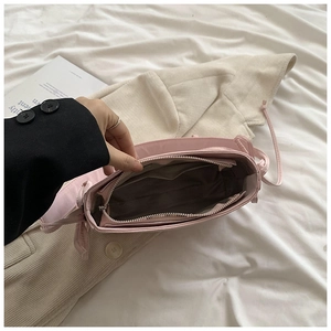 Vue détaillée de l'intérieur du sac rose avec compartiment principal et poche zippée