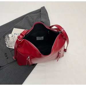 Detail of red patent leather tote bag showing spacious interior and metal zipper hardware