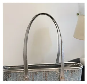 Close-up of slender silver leather strap and metallic sequin detail on large tote bag