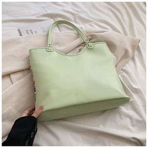 Detail view of the side texture and thickness of this green woven tote bag