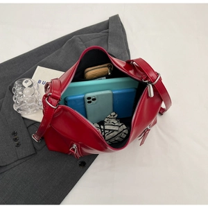 Spacious interior of red leather tote bag holding tablet, phone, and daily essentials