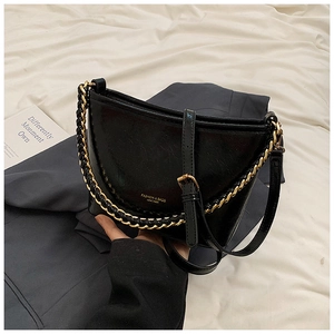Detail of black leather shoulder bag with adjustable strap and gold chain handle