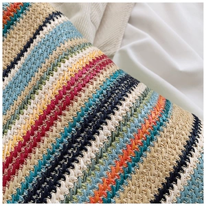 Macro shot of colorful woven straw tote bag with vibrant multi-colored stripes and texture