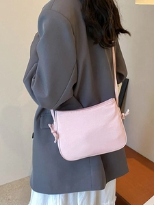Sac bandoulière carré rose pâle minimaliste avec détail de nœud sur la bandoulière