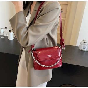 Detail of red leather bucket bag with silver chain and knotted shoulder strap