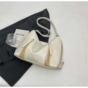 Detail of cream white faux leather bag with decorative dual zippers and adjustable strap