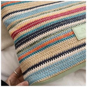 Detailed close-up of rainbow striped straw tote bag with mint green leather brand logo