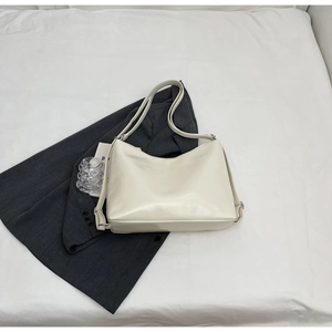 Detailed close-up of cream-white PU leather hobo bag with silver metallic buckles