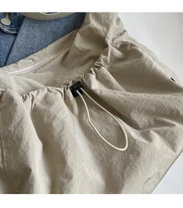 Detail of nylon bag drawstring closure with black buckle on denim background