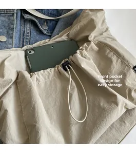 Detailed front pocket design of nylon tote bag showing tablet storage and storage capacity
