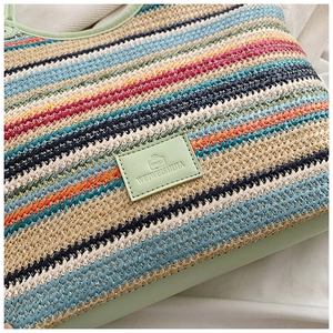 Close-up of colorful striped woven tote bag with a light green leather logo label