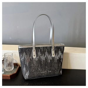 Detail of silver sequin geometric wave pattern and metallic handle on large tote bag