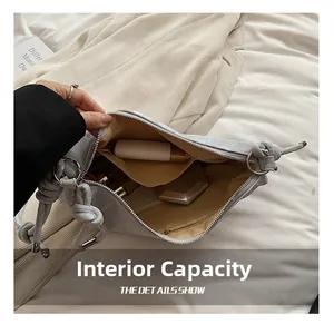 Detail view of the spacious internal compartments and silver zippers of the gray handbag