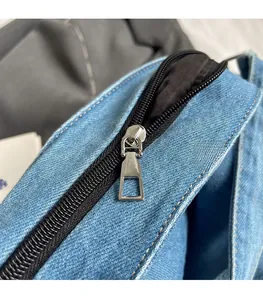 Detailed macro of smooth silver metal zipper on blue twill denim bag with black lining