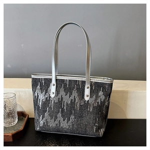 Close-up of silver sequin geometric patterns and durable rivet handles on tote bag