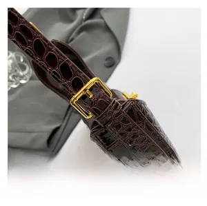 Vue détaillée de la bandoulière marron foncé à motif crocodile avec boucle dorée réglable