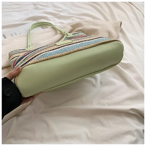 Detail of multi-color woven tote bag with light green leather base and slim handles