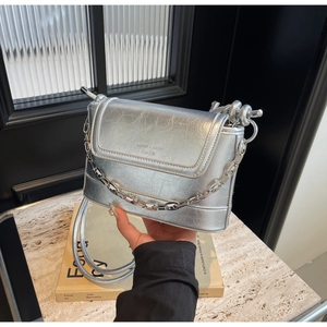 Detailed shot of silver bucket bag with crinkled texture and bold chain decoration