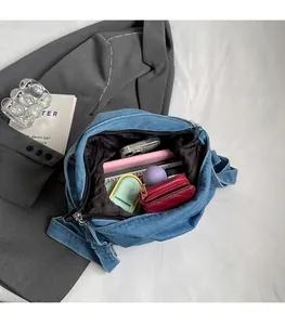 Spacious interior of blue denim tote bag showing black lining and zip closure