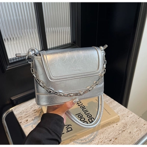 Detail of silver metallic bucket bag with cracked texture leather and chain