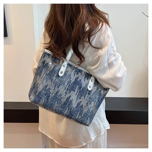 Detail view of large tote bag with blue sequined stripes and white leather rivet straps