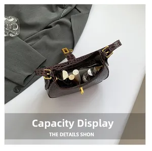 Vue de la capacité du sac à main marron à motif crocodile avec téléphone et maquillage