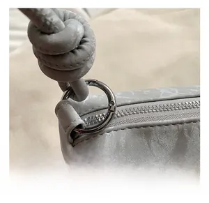 Detailed macro view of gray leather knot strap with silver metal hook and zipper