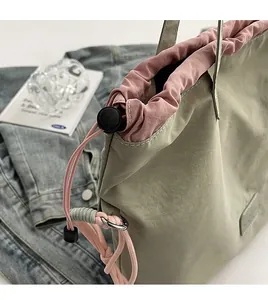Detail of light green canvas tote bag with contrast pink drawstring closure design