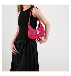Détail du sac demi-lune rose vif à motif crocodile et boucle dorée élégante