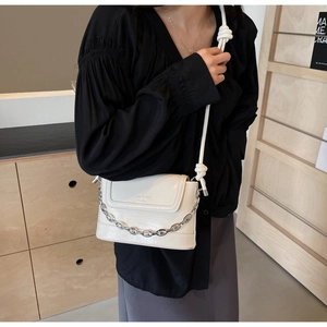 Detail of cream white crossbody bag with silver chain and knotted rope strap