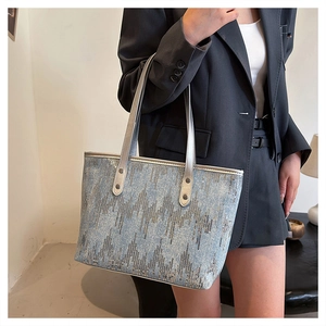 Close-up of blue sequin tote bag with silver leather handles and wave patterns
