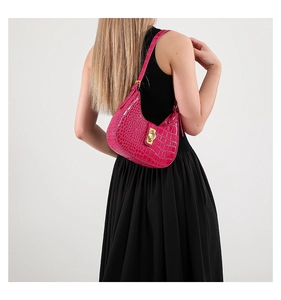 Détail d'un sac hobo fuchsia effet crocodile avec fermoir rectangulaire en métal doré