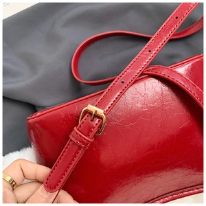 Macro shot of red patent leather texture and gold metal buckle on shoulder strap