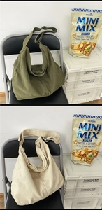 Detail of adjustable wide straps and zip closure on green and beige canvas tote bags